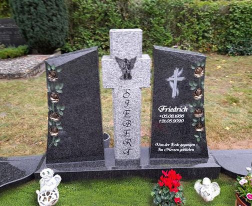 Ein Doppelgrab mit einem Kreuz und bunten Blumen, das eine ruhige und respektvolle Atmosphäre ausstrahlt