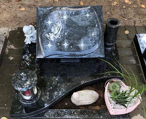 Ein Urnengrab mit einem schwarzen Stein, der mit einem Stern verziert ist, symbolisiert Erinnerung und Trauer